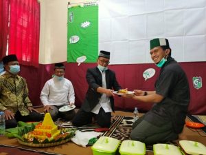 Ketua KAHMI Wamena membagi Potongan Kue Tumpeng Ke PJ Ketua Umum Kom Wamena